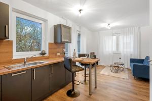 eine Küche und ein Wohnzimmer mit einem Tisch und einem Waschbecken in der Unterkunft Nadorst Residenz in Oldenburg
