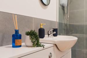 a bathroom with a sink and a blue bottle on a counter at Brand New Must See Stylish Apt W/Free Parking in Leicester