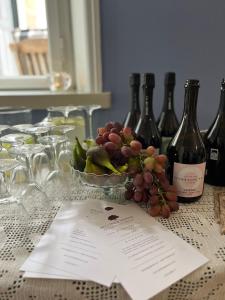 una mesa con botellas de vino y un tazón de uvas en Bellinge House en Horreby