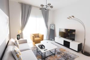 uma sala de estar com um sofá e uma TV em CozyCorner - Gym & Pool Access - Reem Island em Abu Dhabi