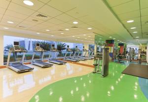 a gym with a row of treadmills and ellipticals at CozyCorner - Gym & Pool Access - Reem Island in Abu Dhabi