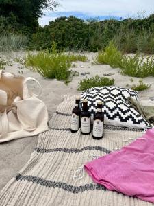 three bottles of beer sitting on a blanket on the beach at Bellinge House in Horreby