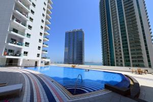 a swimming pool in the middle of two tall buildings at CozyCorner - Gym & Pool Access - Reem Island in Abu Dhabi