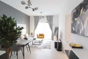 uma sala de estar com uma mesa e um sofá em CozyCorner - Gym & Pool Access - Reem Island em Abu Dhabi
