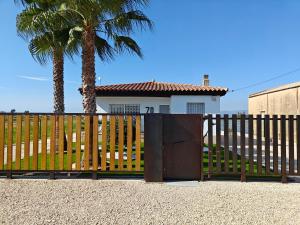 un cancello di fronte a una casa con una palma di La caseta del canal a Deltebre