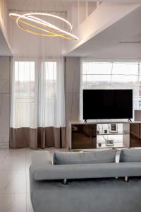 a living room with a couch and a flat screen tv at ForS Resort & Spa in Belgrade