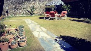 a patio with chairs and tables and potted plants at Urban Lodge in Abbottabad