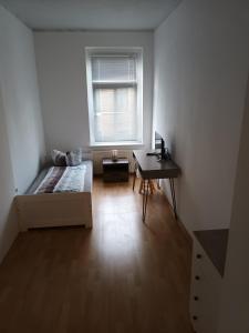 een slaapkamer met een bed, een bureau en een raam bij Rockys Ferienwohnung Mitte in Markkleeberg