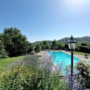 una piscina con un poste de luz y flores en Borgo il cantuccio - Casa Simona con piscina condivisa, en Molino di Renzetti