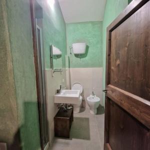 baño verde con aseo y lavamanos en Borgo il cantuccio - Casa Simona con piscina condivisa, en Molino di Renzetti