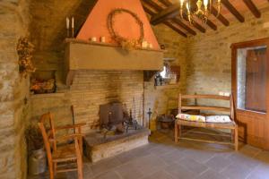 a living room with a fireplace and a table and chairs at Borgo il cantuccio - Casa Simona con piscina condivisa in Molino di Renzetti