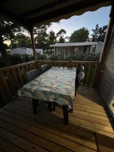 eine Holzterrasse mit einem Tisch und Stühlen darauf in der Unterkunft Chez Vane et JP in Lège-Cap-Ferret + 1 Foto