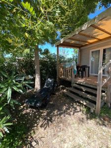 eine Veranda eines Hauses mit einer Bank und einem Tisch in der Unterkunft Chez Vane et JP in Lège-Cap-Ferret