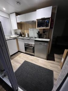 eine Küche mit weißen Schränken und einem Herd mit Backofen in der Unterkunft Chez Vane et JP in Lège-Cap-Ferret