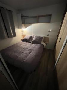 ein großes Bett in einem kleinen Zimmer in der Unterkunft Chez Vane et JP in Lège-Cap-Ferret