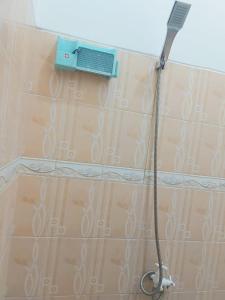 eine Dusche mit einem Schlauch an einer gefliesten Wand in der Unterkunft FAZILA homestay in Yogyakarta