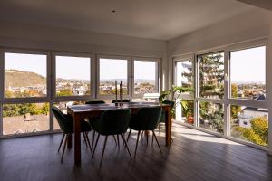 a dining room with a table and chairs and windows at Design Apartment zentral für 6 in Andernach: Ausblick, WiFi, Küche in Andernach
