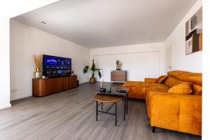 a living room with a couch and a table at Design Apartment zentral für 6 in Andernach: Ausblick, WiFi, Küche in Andernach
