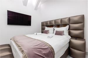 a bedroom with a large bed and a flat screen tv at ForS Resort & Spa in Belgrade