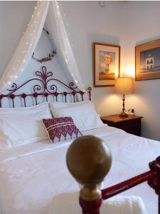 a bedroom with a white bed with a canopy at Aphrodite's Coast Retreat House! in Galaxidi