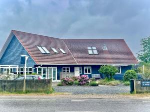 een blauw huis met een bruin dak bij Rørvig Bed & Kitchen in Rørvig