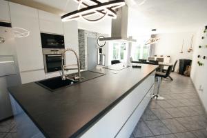 une cuisine avec un comptoir noir dans l'établissement Gîte La Maison de Ludivine avec Terrasse et Parking, à Orbey