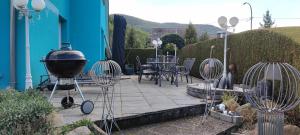 a patio with a grill and a table and chairs at Chez Ludivine - Maison avec Terrasse et Parking in Orbey