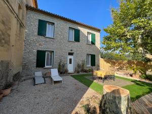 a house with chairs and tables in front of it at Appartements à la ferme in La Ciotat