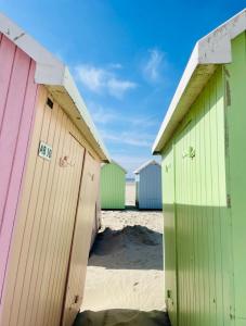 une rangée de cabanes de plage colorées sur une plage dans l'établissement Appart 2 chambres HYPERCENTRE de Berck-Plage - WIFI, à Berck-sur-Mer