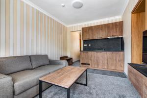 ein Wohnzimmer mit Sofa und Tisch in der Unterkunft Къща за гости Чудните Мостове in Zabŭrdo