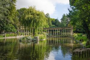 a bridge over a pond in a garden at Typical Chic Parisian Flat-Near les Champs-Élysées in Paris