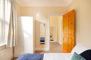 1 dormitorio con 1 cama y puerta de madera en Stylish House in Wimbledon en Londres