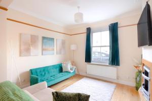 sala de estar con sofá azul y ventana en Stylish House in Wimbledon en Londres