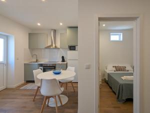 a room with a table and a kitchen and a bed at Canary's Suite in Matosinhos