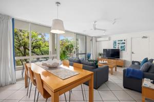 uma sala de estar com uma mesa e uma sala de jantar em Quamby Place, Apt 65 - Garden View em Noosa Heads