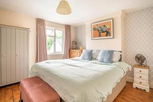 a bedroom with a large bed and a window at Duck Terrace with Gym Duckling Stays in Kibworth Harcourt