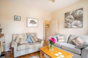 a living room with two couches and a table at Duck terrace in Kibworth Harcourt