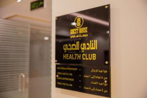 a sign for a health club hanging on a wall at فندق جيست هاوس in Yanbu