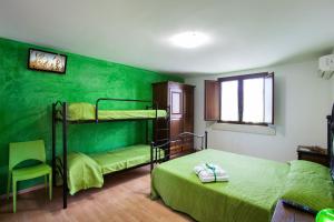 CollepassoにあるB&B Perla del Sudの緑の壁のベッドルーム1室(二段ベッド2組付)
