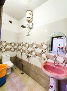 een badkamer met een roze wastafel en een spiegel bij Hotel Royal Pinkcity in Jaipur
