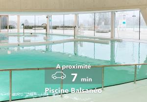 una piscina in un edificio con il testo min. più bilancio plastico di Le Countryside ⸱ Stationnement gratuit ⸱ Fibre a Déols