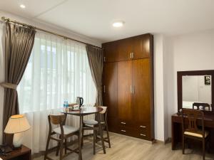 een woonkamer met een tafel en stoelen en een spiegel bij Hoang Yen Hotel - Phu My Hung in Ho Chi Minh-stad