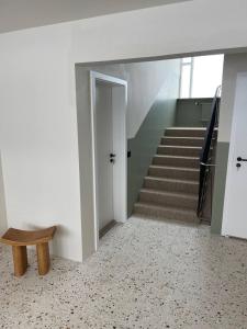 um corredor com uma escada com um banco e uma porta em Dúfan Apartments em Bolungarvík