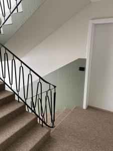 a staircase in a home with a wrought iron railing at Dúfan Apartments in Bolungarvík