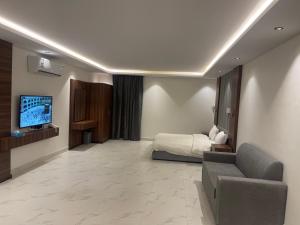 a hotel room with a bed and a couch and a tv at شقق درر رامه للشقق المخدومة 10 in Riyadh