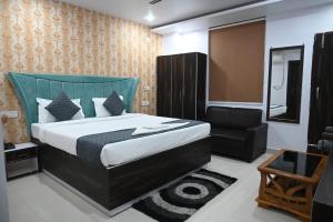 - une chambre avec un grand lit et une chaise dans l'établissement HOTEL DIAMANT INN, à Patna