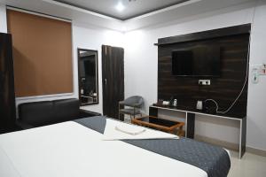 a hotel room with a bed and a flat screen tv at HOTEL DIAMANT INN in Patna