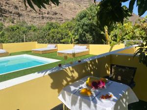 a table with fruit on it next to a swimming pool at SUNNY CARMELITO DELUXE in Mogán