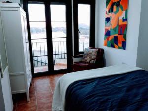 1 dormitorio con 1 cama, 1 silla y ventanas en NO. 32 with stunning views, en Olvera