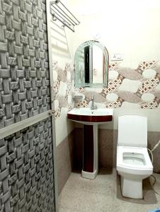 een badkamer met een wastafel, een toilet en een spiegel bij Hotel Royal Pinkcity in Jaipur